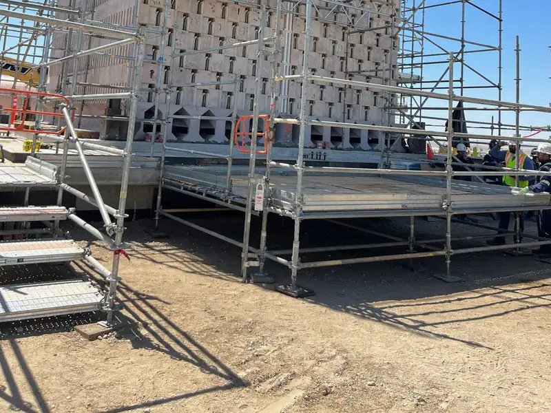 System scaffold with plank decks on several levels against a building facade